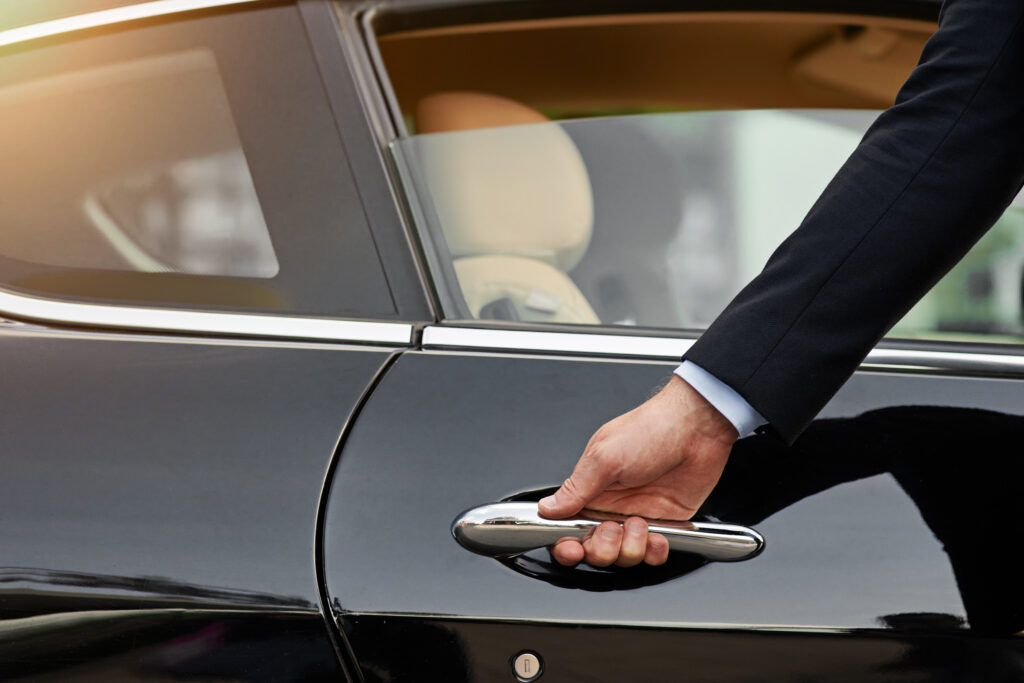 Allow me...Cropped shot of an unrecognizable male chauffeur opening a car door.