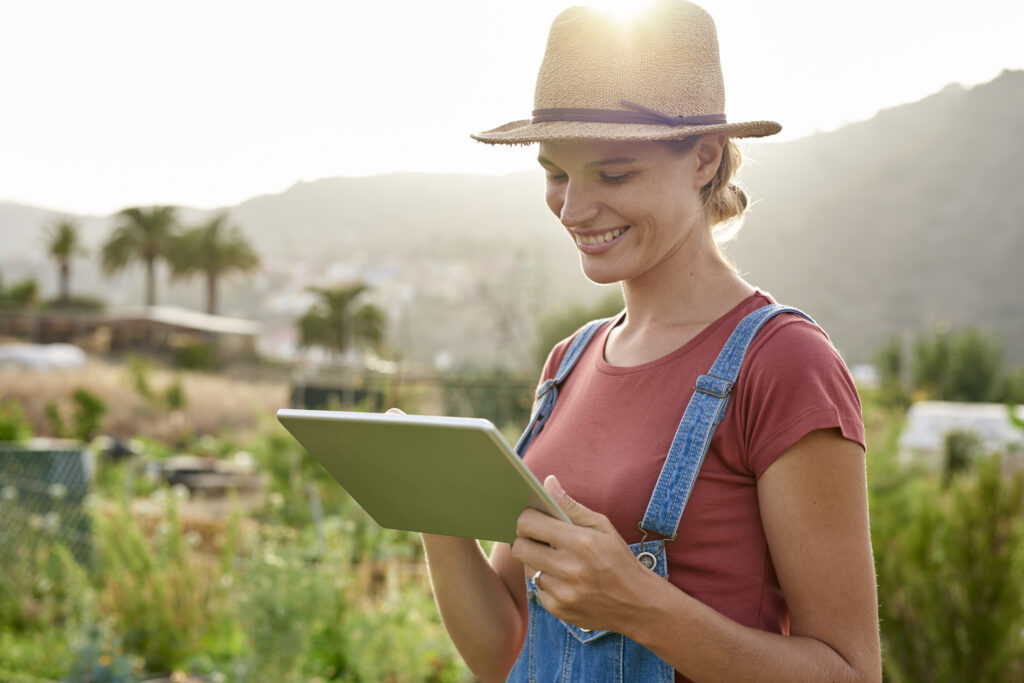 Spain, Canary Islands, Gran Canaria, smiling young woman looking at tablet